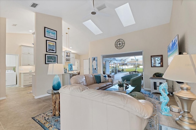 living area with washer / dryer, a skylight, visible vents, and high vaulted ceiling