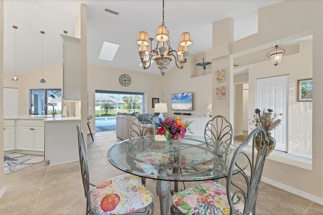 dining area featuring light tile patterned floors, a notable chandelier, high vaulted ceiling, and visible vents