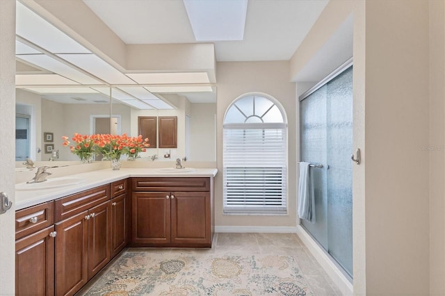 full bath with a shower stall, double vanity, tile patterned floors, and a sink