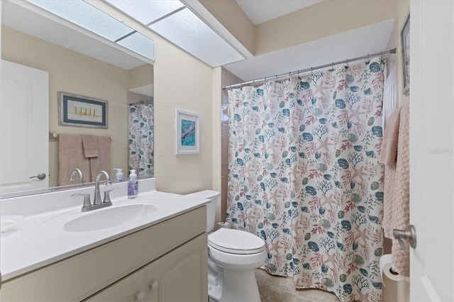 bathroom with toilet, a skylight, a shower with curtain, tile patterned floors, and vanity