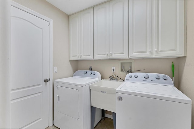 clothes washing area featuring a sink, cabinet space, and separate washer and dryer