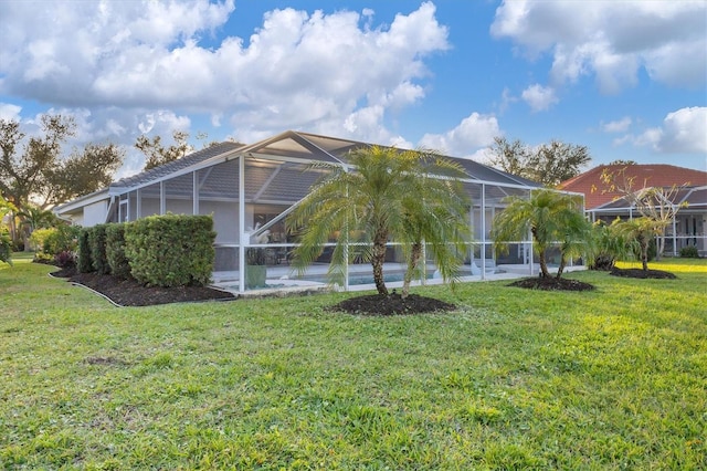 back of property featuring a lanai, a lawn, and an outdoor pool