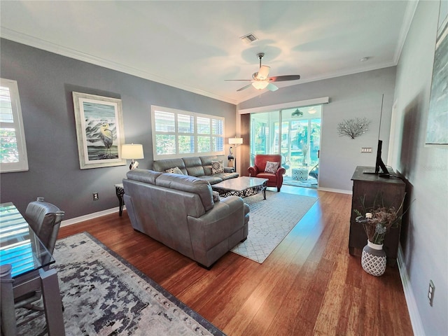 living area with visible vents, baseboards, ornamental molding, wood finished floors, and a ceiling fan