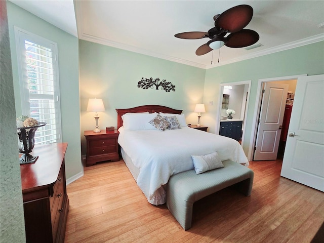 bedroom featuring visible vents, light wood-style flooring, ensuite bathroom, and crown molding