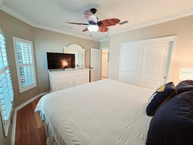 bedroom with wood finished floors, visible vents, ceiling fan, a closet, and crown molding