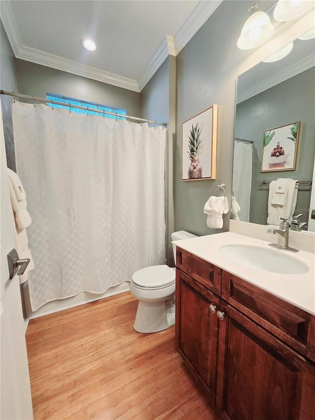 bathroom with wood finished floors, toilet, ornamental molding, and vanity