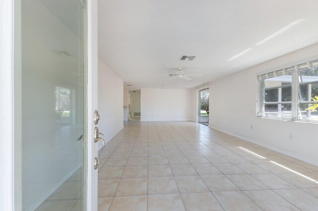 unfurnished room with light tile patterned floors, visible vents, baseboards, and a ceiling fan