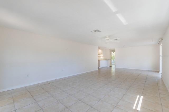 empty room with light tile patterned floors, visible vents, baseboards, and ceiling fan