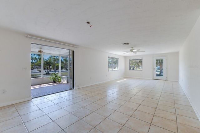 spare room featuring light tile patterned floors, visible vents, baseboards, and ceiling fan