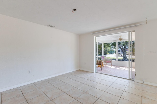 spare room with light tile patterned floors, baseboards, visible vents, and ceiling fan