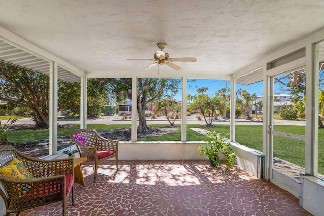 unfurnished sunroom featuring a ceiling fan and a healthy amount of sunlight