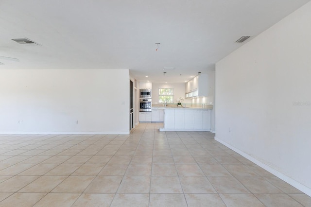 unfurnished living room with light tile patterned floors, baseboards, and visible vents