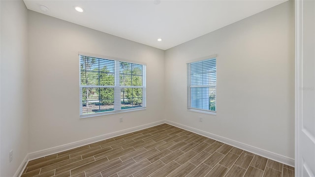 empty room with recessed lighting, baseboards, and wood tiled floor