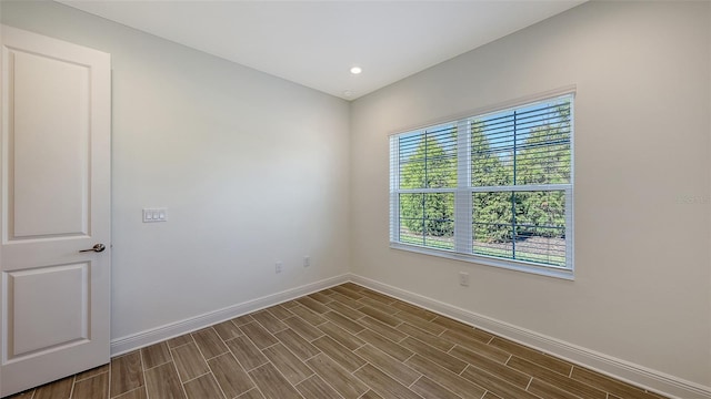 spare room featuring recessed lighting, baseboards, and wood tiled floor