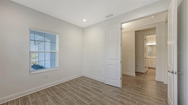 spare room featuring visible vents, recessed lighting, baseboards, and wood tiled floor