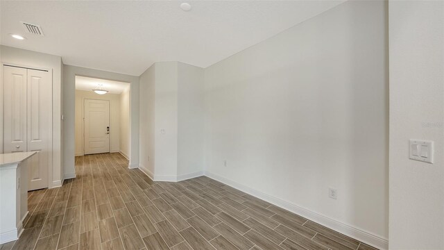 spare room with recessed lighting, visible vents, baseboards, and wood tiled floor
