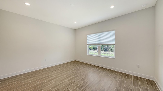 empty room with recessed lighting, baseboards, and wood finished floors