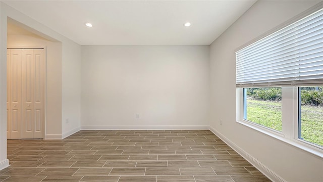 empty room with recessed lighting, baseboards, and wood finish floors