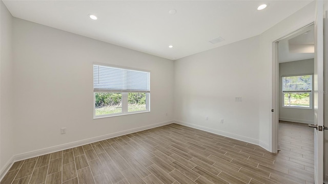 unfurnished room with wood finished floors, recessed lighting, and baseboards
