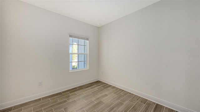 empty room featuring baseboards and wood tiled floor