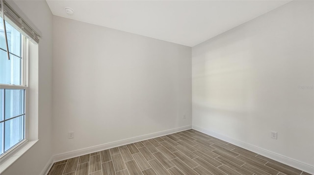 spare room featuring baseboards and wood tiled floor