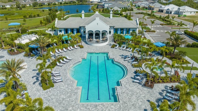 view of pool with a patio area, a water view, and a residential view