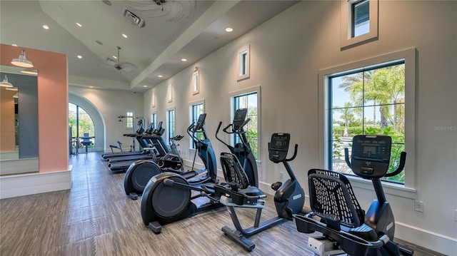 exercise room featuring visible vents, recessed lighting, high vaulted ceiling, and baseboards