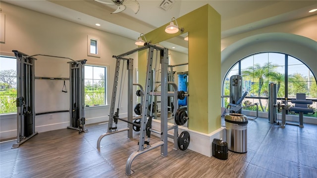 exercise room with wood finished floors, recessed lighting, visible vents, and baseboards