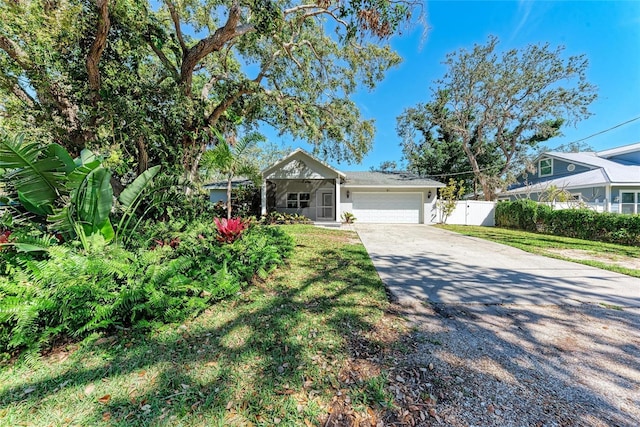 view of front of house featuring a garage, concrete driveway, and fence