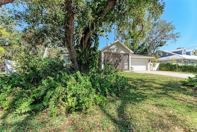 view of front of property featuring a garage, a front lawn, and driveway