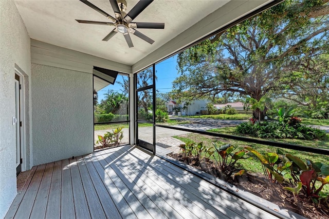 unfurnished sunroom featuring ceiling fan