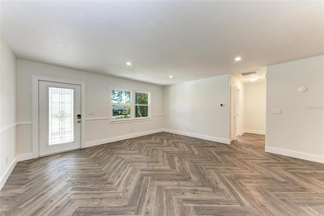 empty room with recessed lighting, visible vents, and baseboards