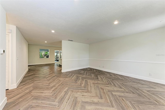 spare room featuring recessed lighting, visible vents, baseboards, and a textured ceiling