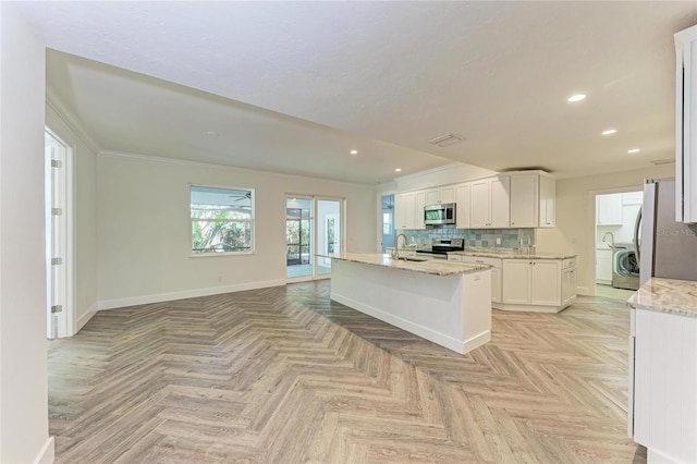 kitchen featuring a sink, white cabinetry, stainless steel appliances, decorative backsplash, and baseboards