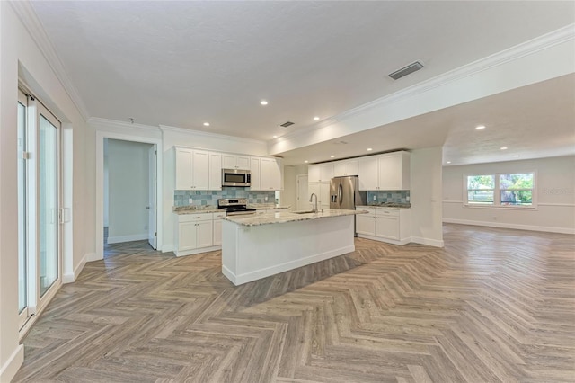 kitchen with a sink, open floor plan, backsplash, and stainless steel appliances