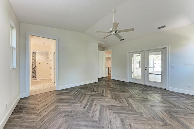 spare room featuring visible vents, lofted ceiling, a ceiling fan, french doors, and baseboards