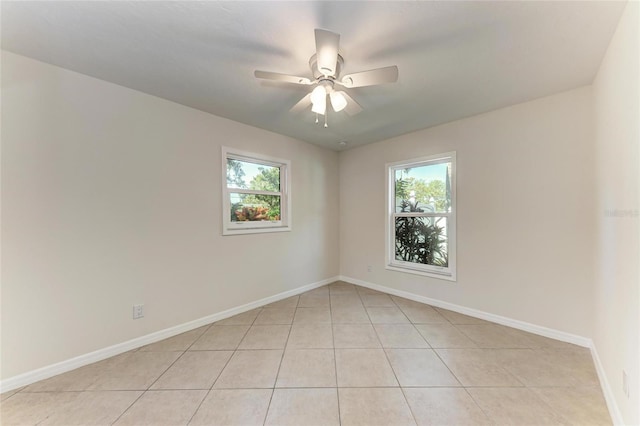 empty room featuring baseboards, a wealth of natural light, and ceiling fan