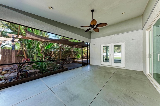 unfurnished sunroom with french doors and a ceiling fan