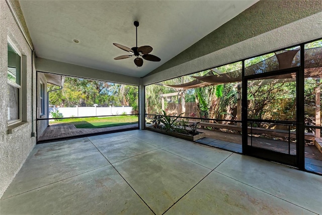 unfurnished sunroom with ceiling fan and vaulted ceiling