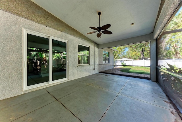 unfurnished sunroom with lofted ceiling and a ceiling fan