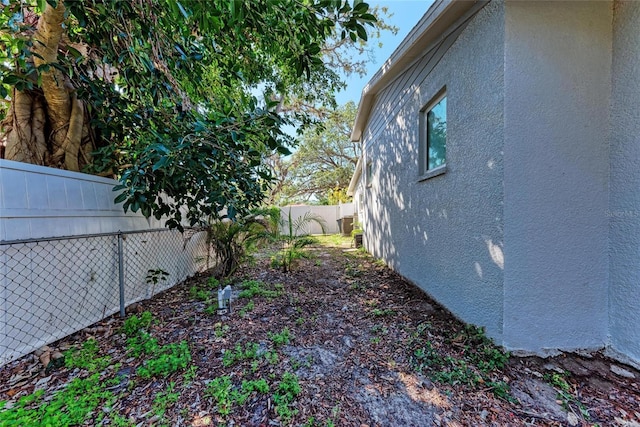 view of side of home with stucco siding and a fenced backyard