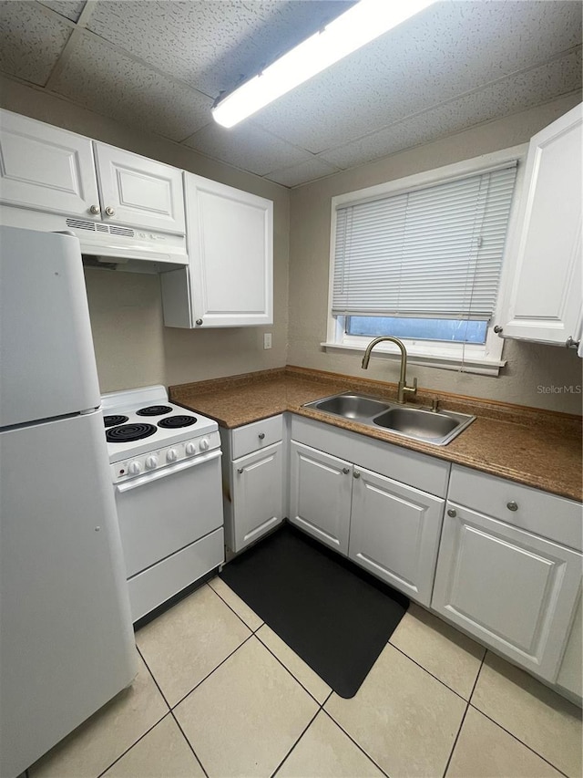 kitchen featuring under cabinet range hood, white appliances, white cabinetry, and a sink