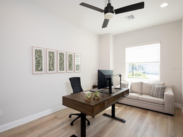 home office featuring visible vents, a ceiling fan, baseboards, and light wood finished floors