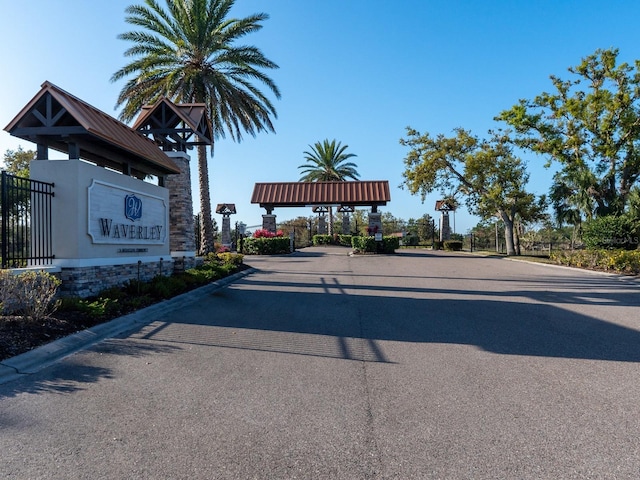 view of road with a gated entry and curbs