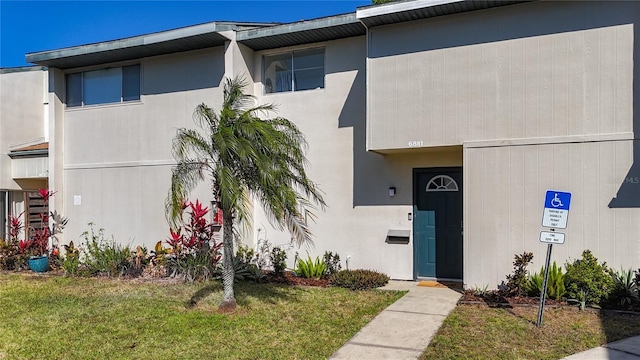 view of front of home with stucco siding and a front yard