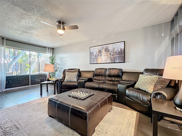 living area with tile patterned floors, a ceiling fan, and a textured ceiling