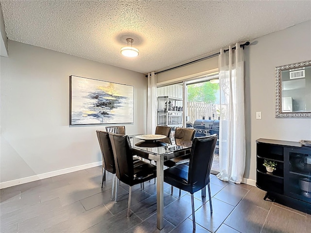 dining area featuring baseboards and a textured ceiling