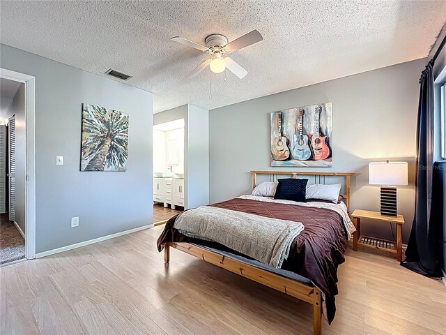 bedroom featuring a ceiling fan, baseboards, visible vents, light wood-style floors, and a textured ceiling