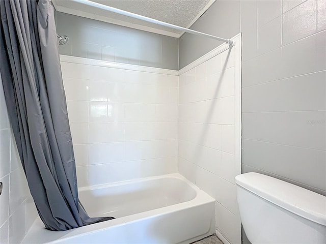 bathroom with shower / bath combination with curtain, a textured ceiling, toilet, and tile walls