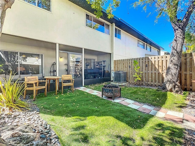 back of house with cooling unit, a yard, and fence